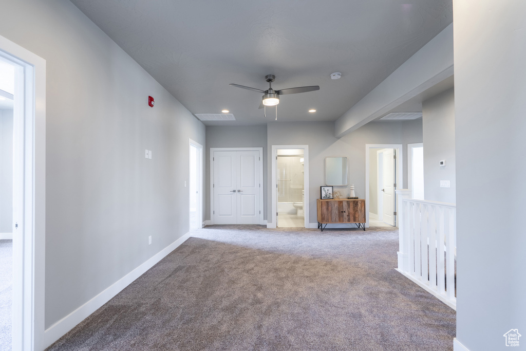 Carpeted empty room with ceiling fan and a healthy amount of sunlight