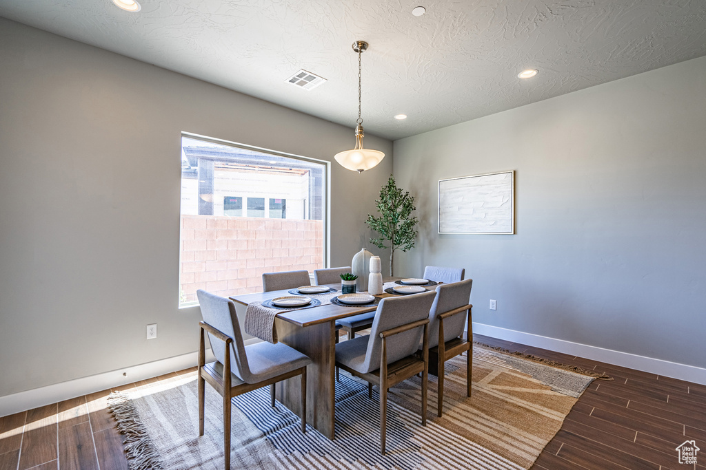 Dining area featuring a textured ceiling and dark hardwood / wood-style floors