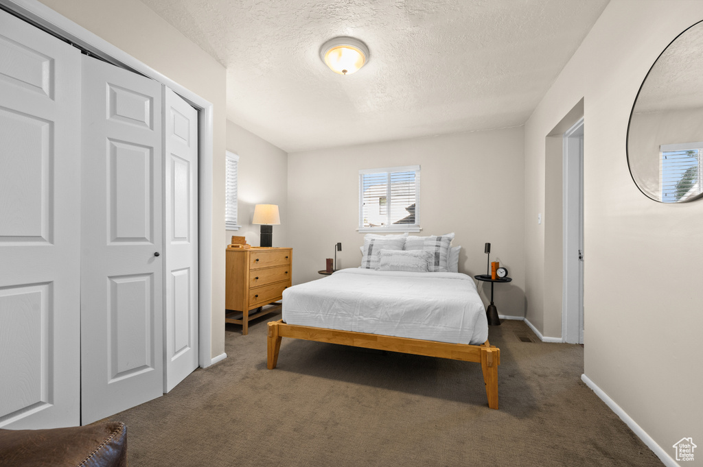 Bedroom featuring a textured ceiling and carpet