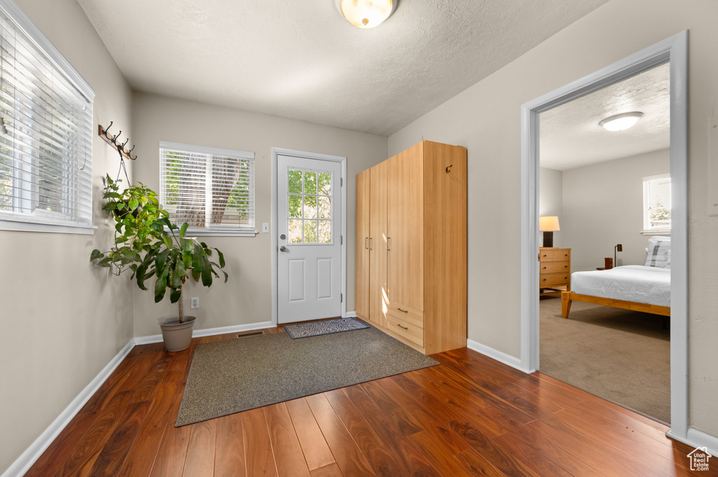 Foyer with a textured ceiling and dark hardwood / wood-style flooring