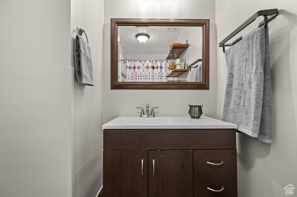 Bathroom featuring a textured ceiling and vanity