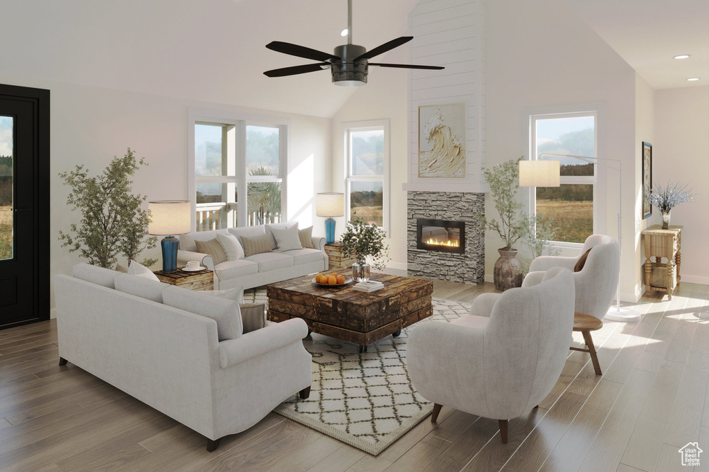 Living room with high vaulted ceiling, light hardwood / wood-style flooring, and a healthy amount of sunlight