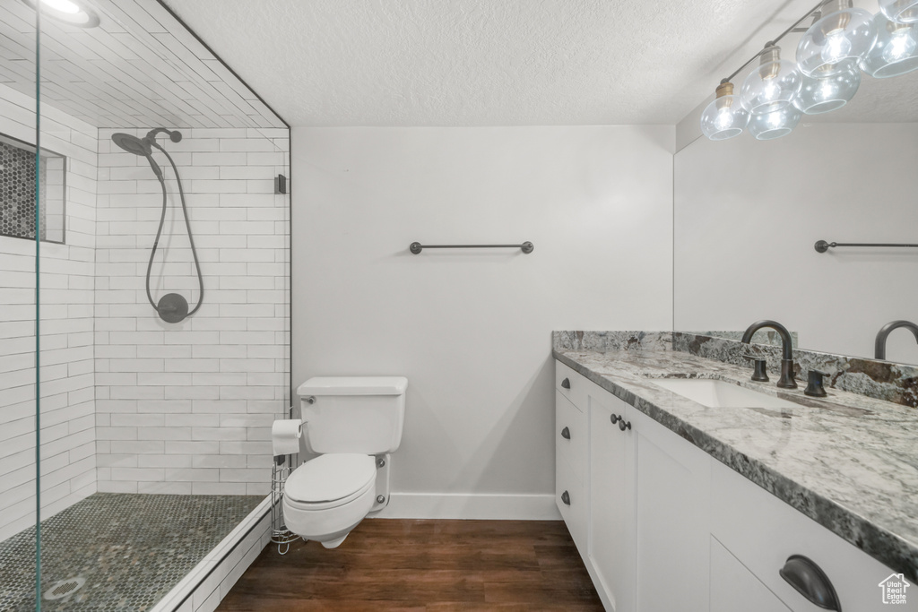 Bathroom with vanity, an enclosed shower, wood-type flooring, a textured ceiling, and toilet