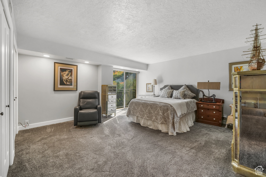 Bedroom with carpet flooring, a textured ceiling, and access to outside