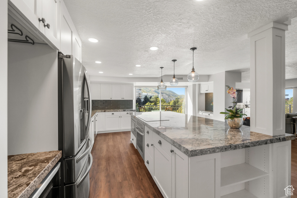 Kitchen featuring dark stone countertops, white cabinetry, dark hardwood / wood-style flooring, and a wealth of natural light