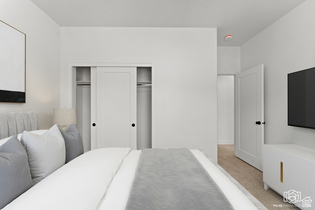 Bedroom featuring light colored carpet and a closet