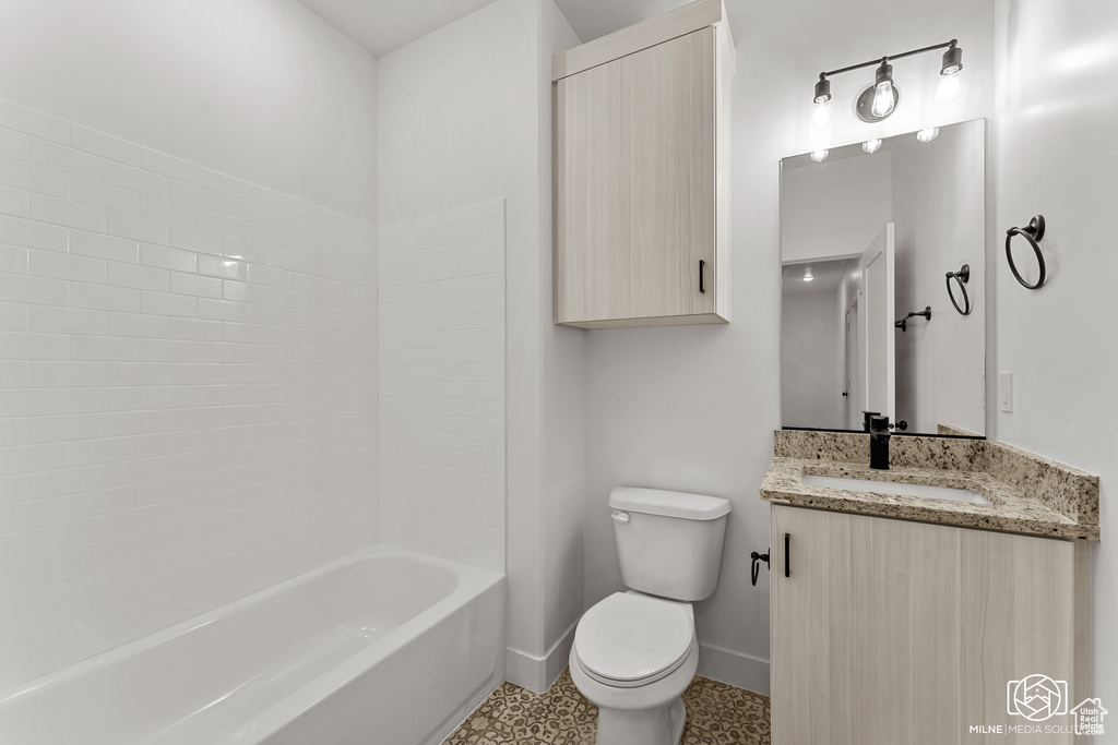 Full bathroom featuring tub / shower combination, vanity, and toilet