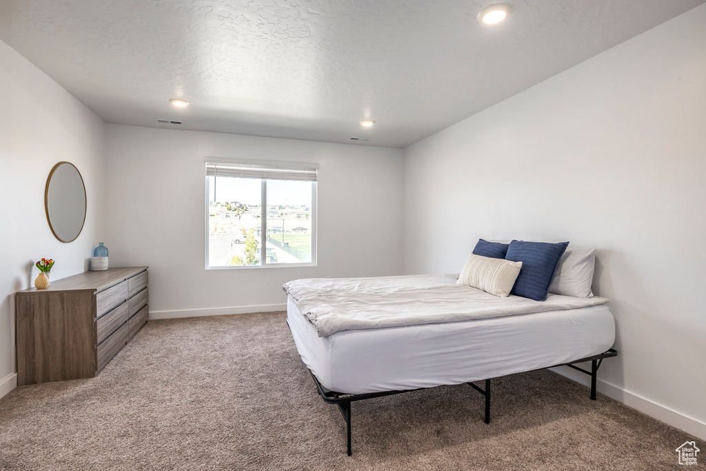 Bedroom with a textured ceiling and carpet