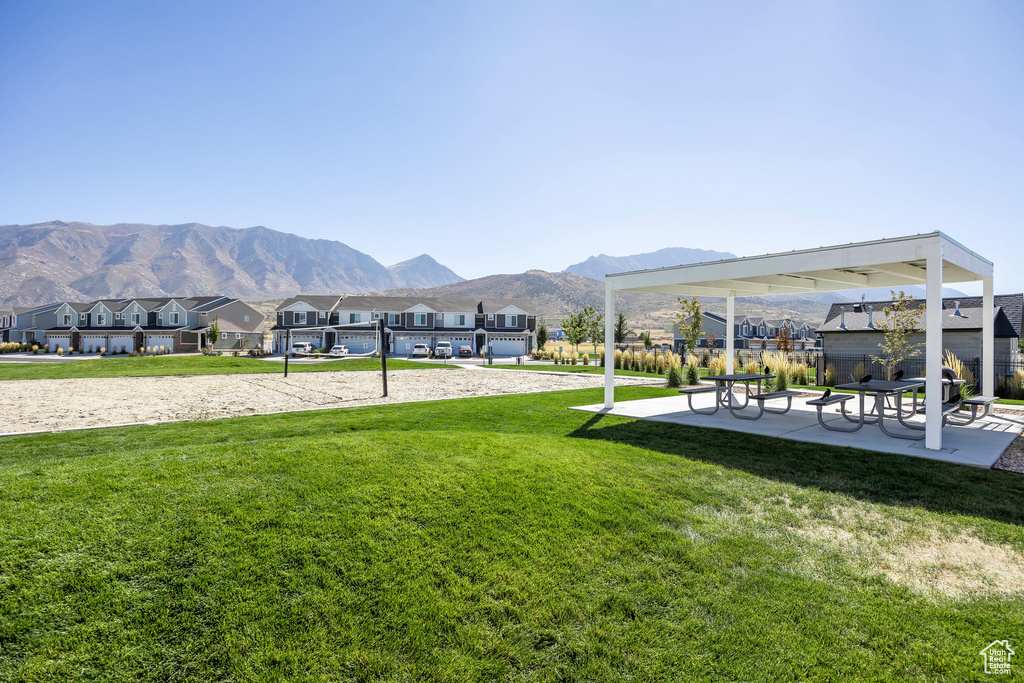 Surrounding community featuring a mountain view, volleyball court, and a yard