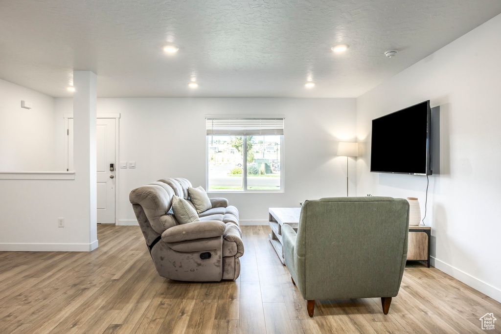 Living room with a textured ceiling and light wood-type flooring