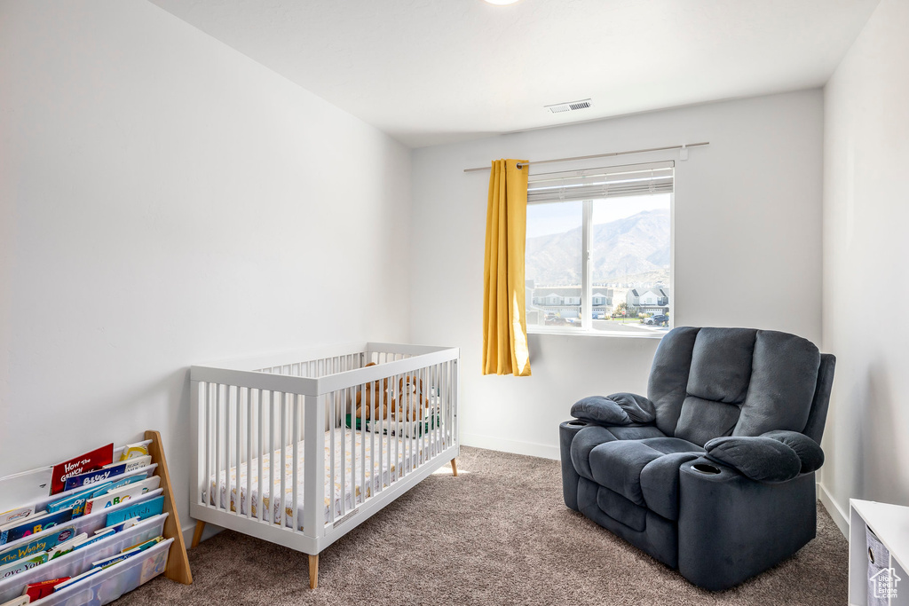 Carpeted bedroom featuring a mountain view and a crib