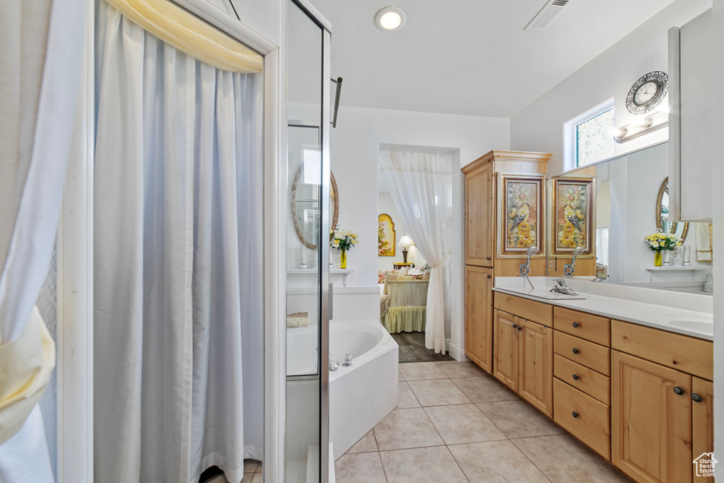 Bathroom featuring vanity, tile patterned floors, and a tub