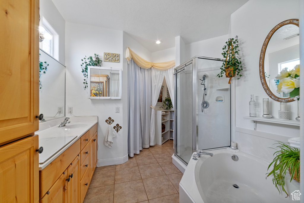 Bathroom with shower with separate bathtub, vanity, and tile patterned floors