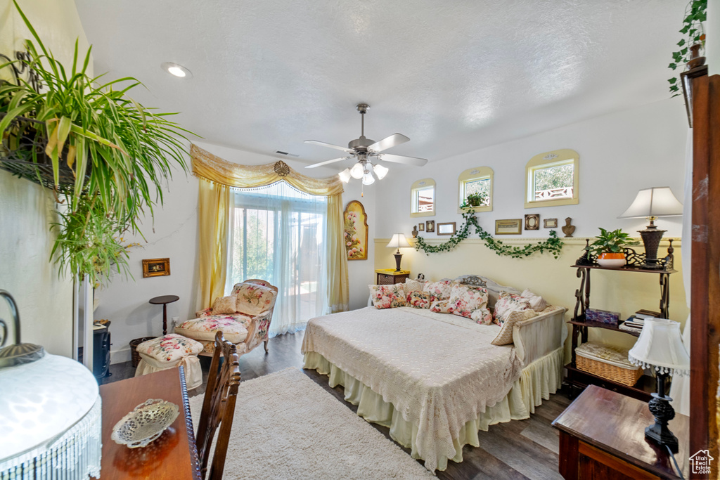 Bedroom featuring a textured ceiling, ceiling fan, and dark hardwood / wood-style flooring