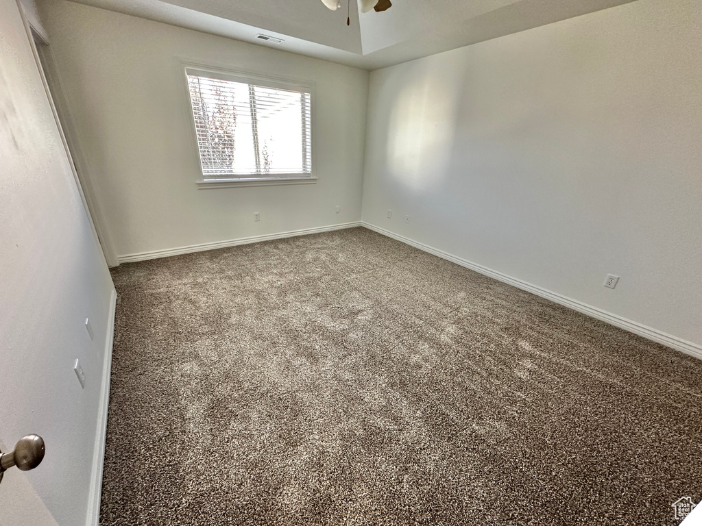 Empty room featuring ceiling fan and carpet