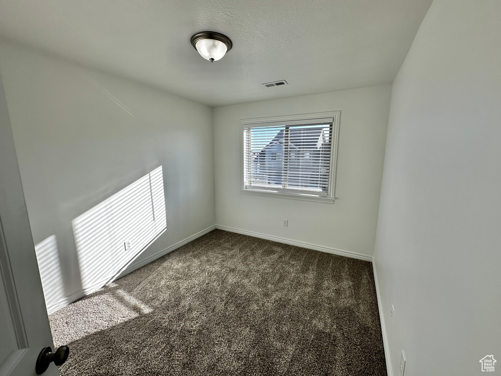 Unfurnished room with dark carpet