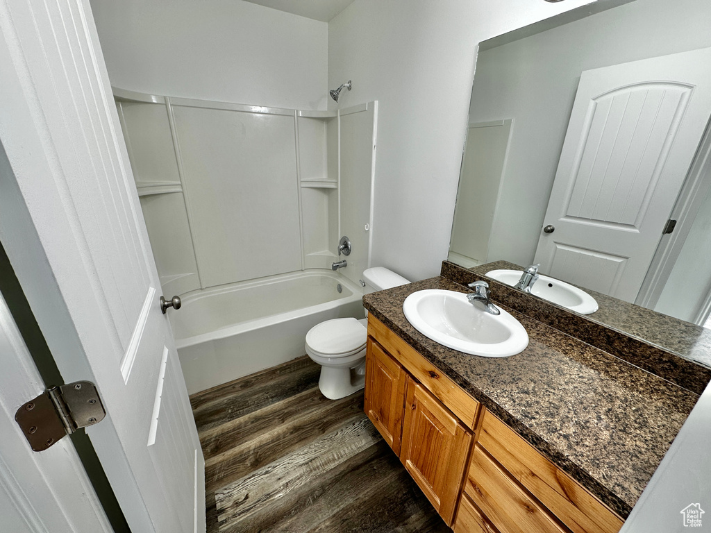 Full bathroom with vanity, shower / bath combination, hardwood / wood-style floors, and toilet