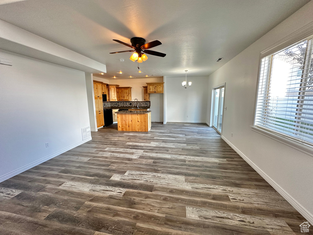 Unfurnished living room featuring ceiling fan, sink, and dark hardwood / wood-style flooring