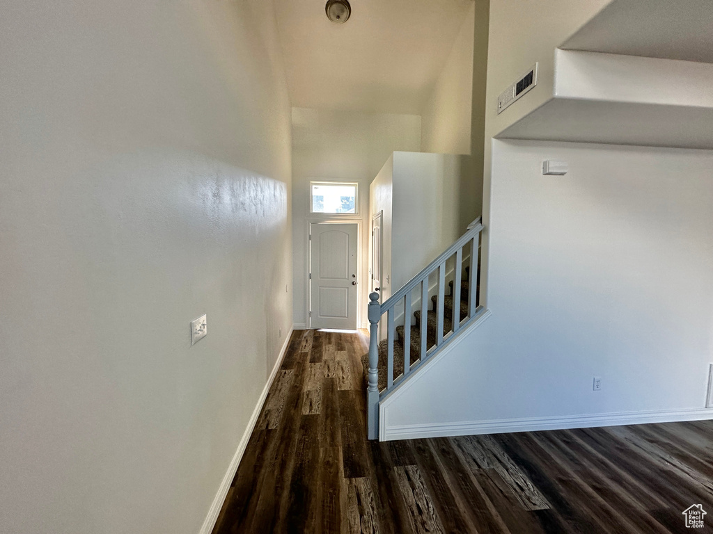 Staircase with hardwood / wood-style floors and a high ceiling