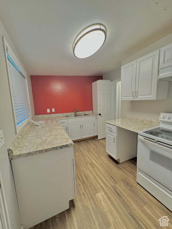 Kitchen with sink, white cabinetry, kitchen peninsula, light hardwood / wood-style flooring, and white electric range