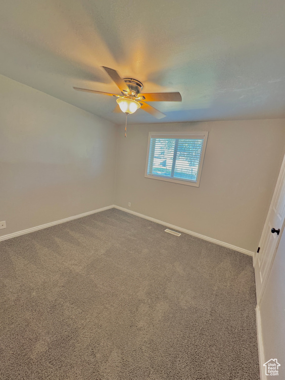 Carpeted empty room with ceiling fan