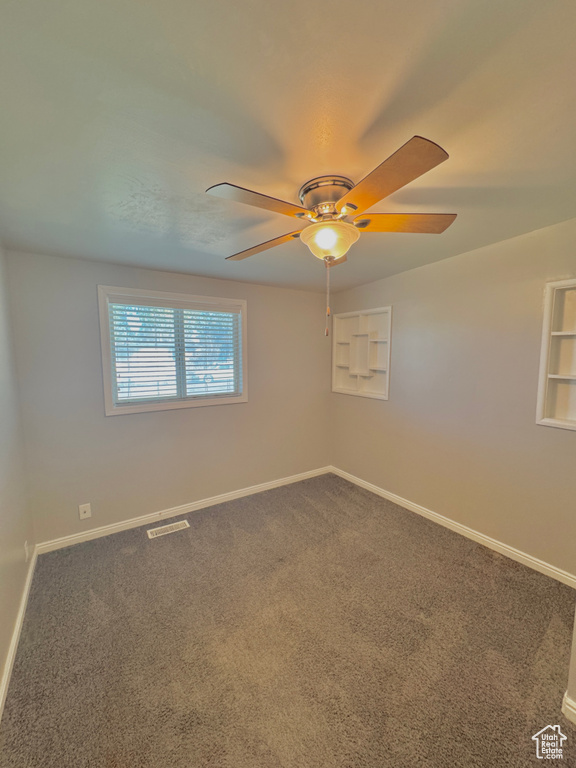 Carpeted spare room with ceiling fan