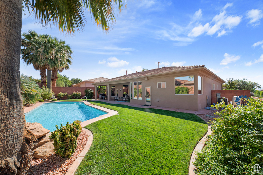 View of swimming pool featuring a patio and a yard