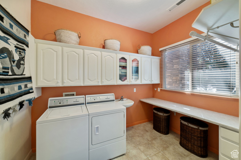 Laundry room featuring cabinets, washer and dryer, and sink