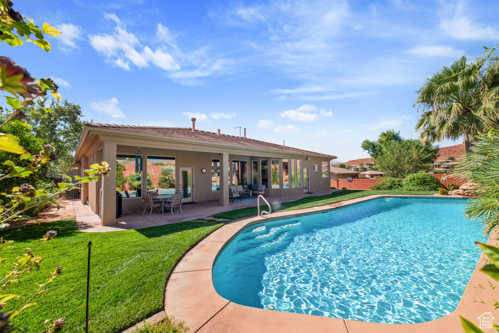 View of pool with a patio and a yard