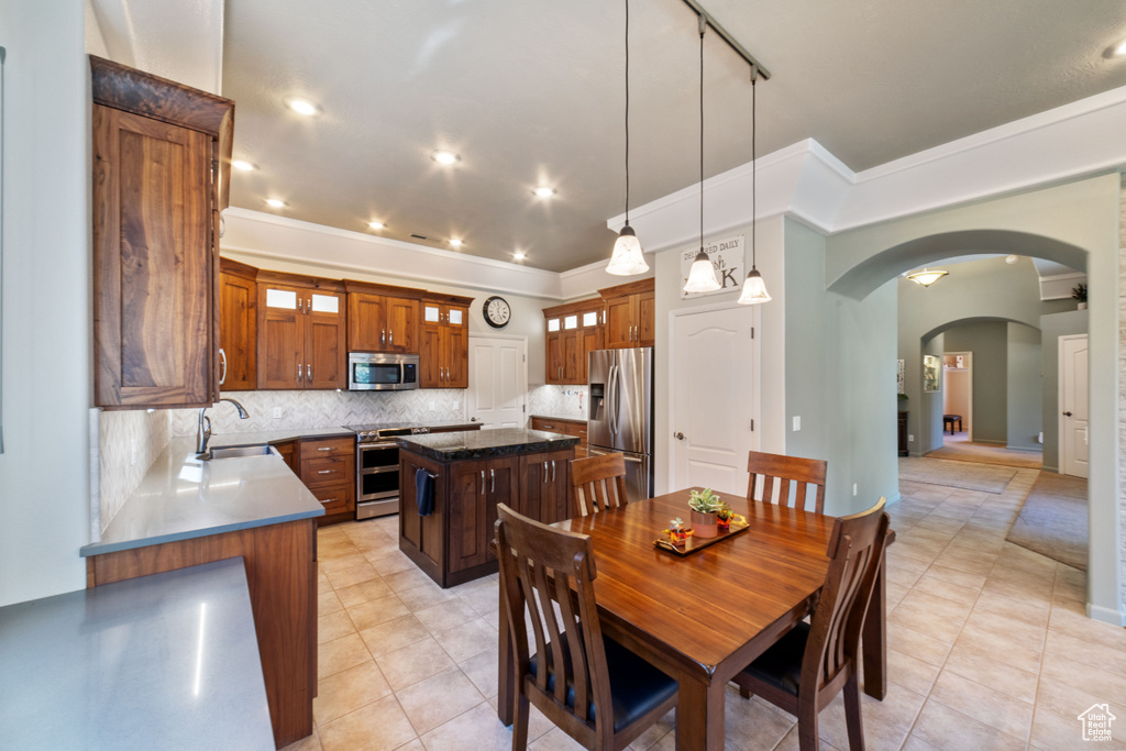 Tiled dining room featuring sink and ornamental molding