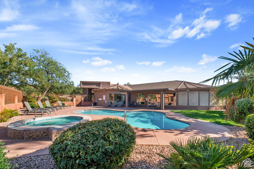 View of swimming pool with a patio and an in ground hot tub