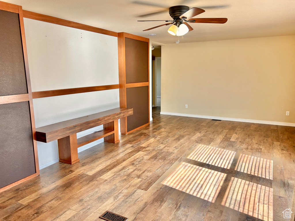 Empty room featuring wood-type flooring and ceiling fan