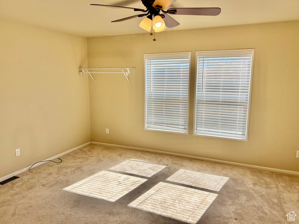 Empty room featuring light carpet and ceiling fan