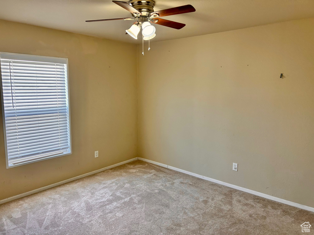 Unfurnished room featuring ceiling fan and light colored carpet