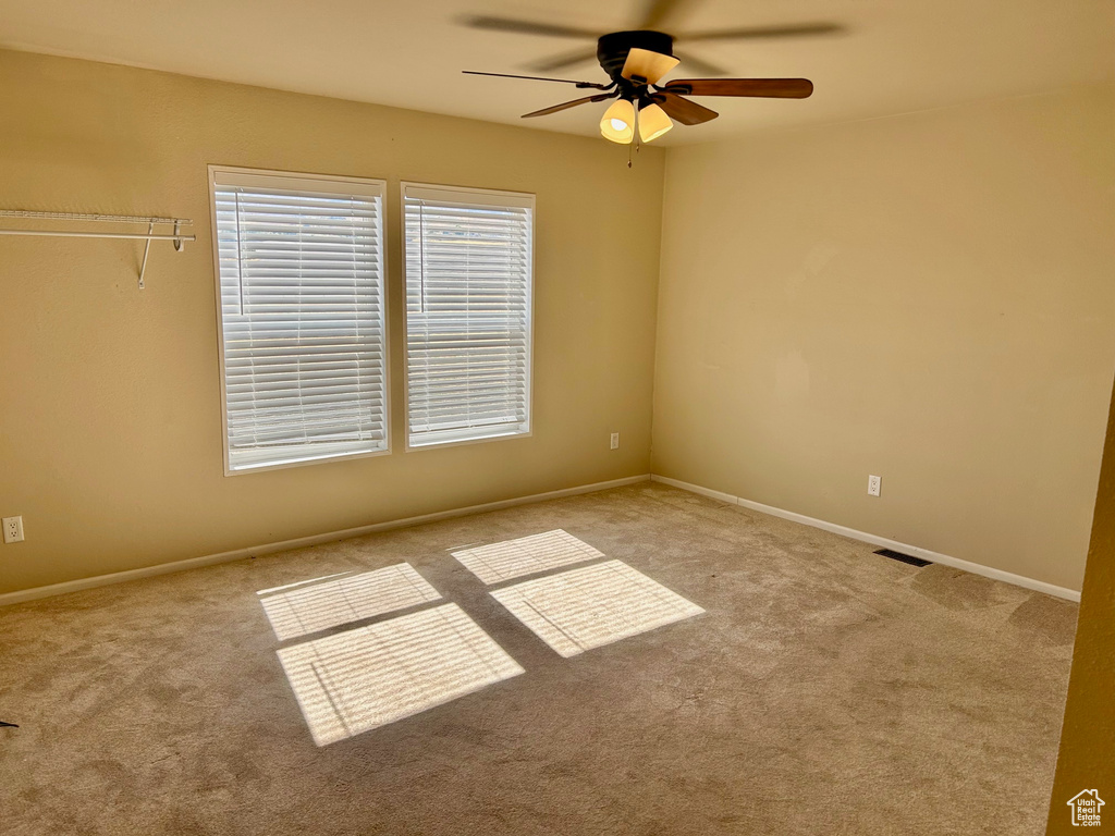 Carpeted spare room with ceiling fan