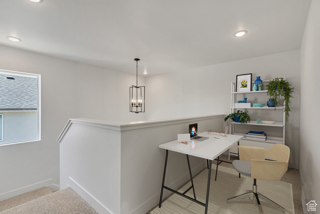 Office space with an inviting chandelier and light carpet