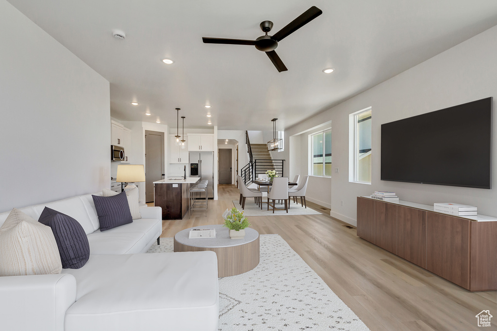 Living room with light wood-type flooring and ceiling fan