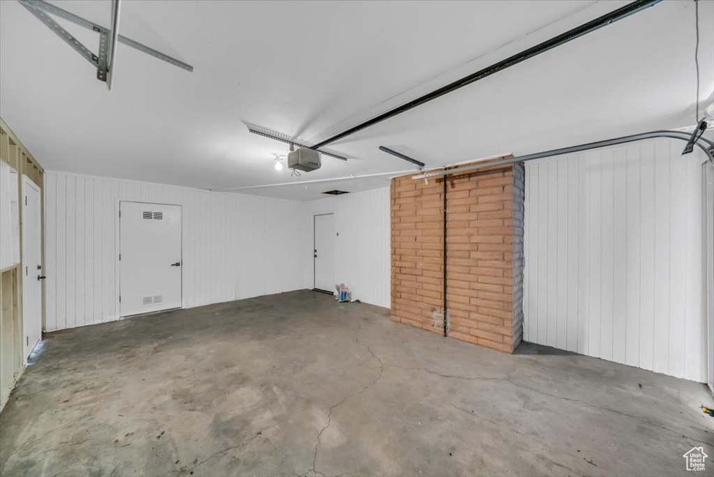 Garage featuring a garage door opener and wood walls