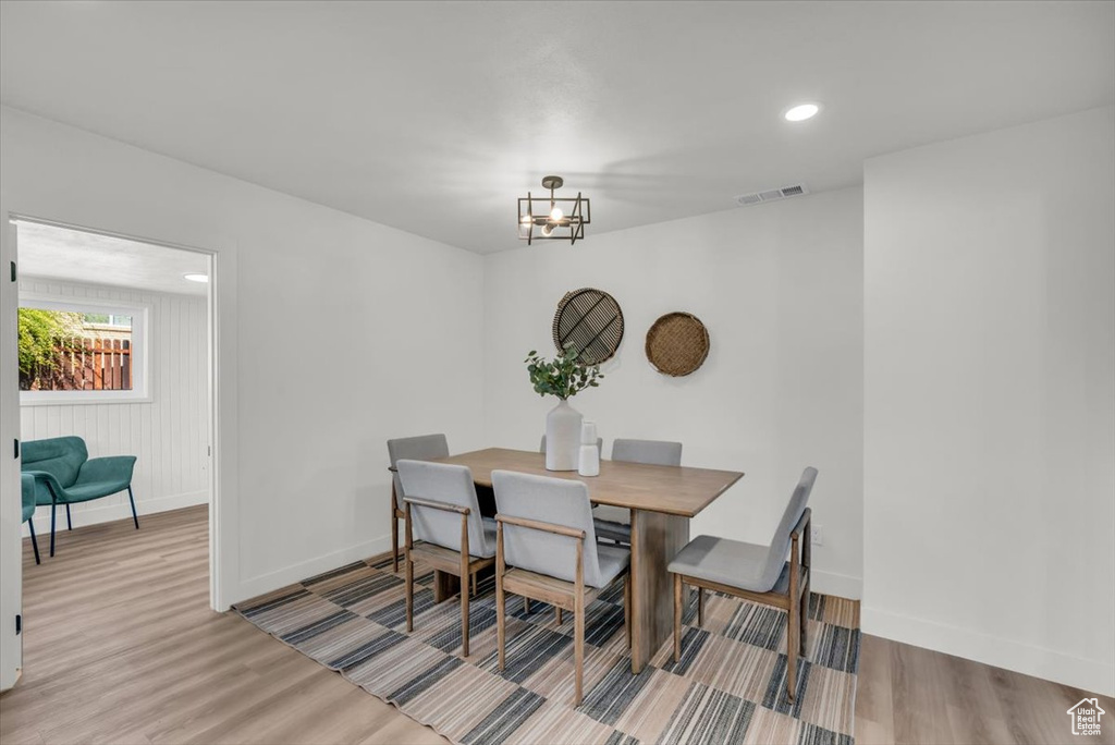 Dining room with an inviting chandelier and light hardwood / wood-style flooring