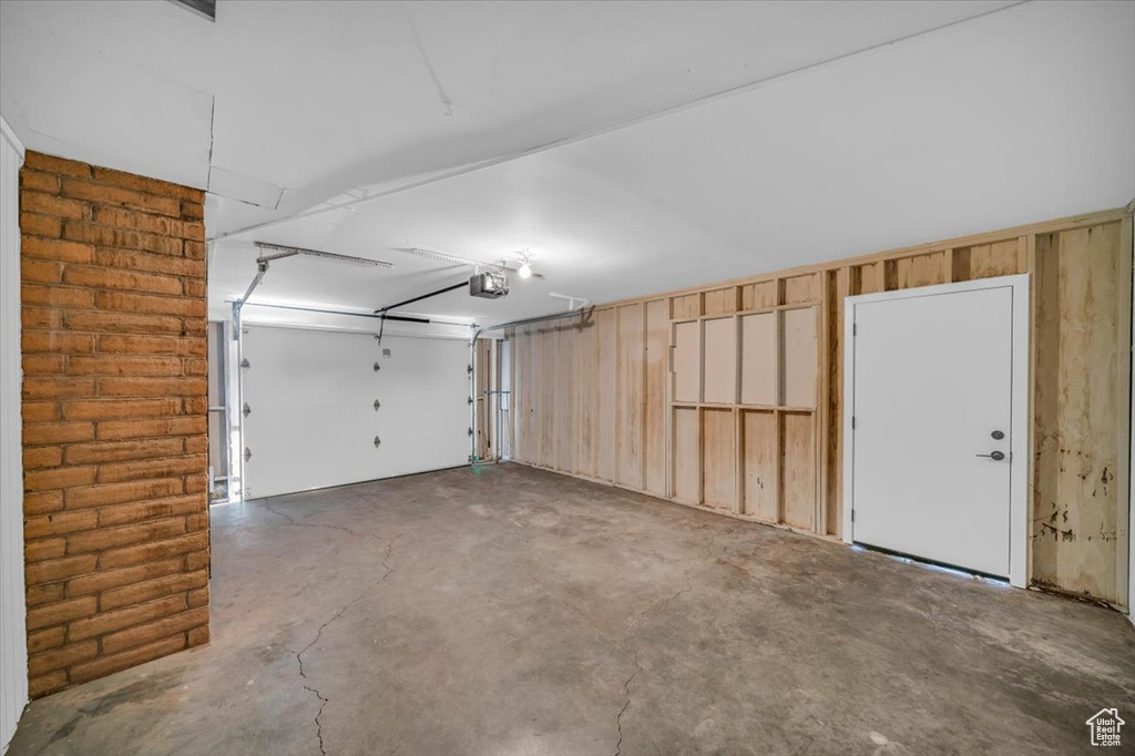 Garage featuring a garage door opener and wood walls