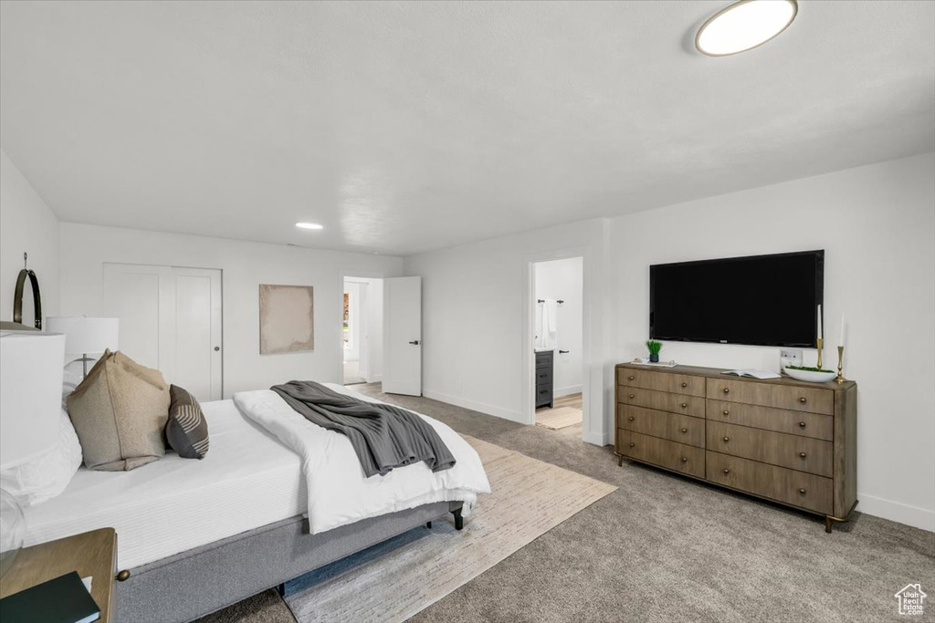 Bedroom featuring light carpet and ensuite bath