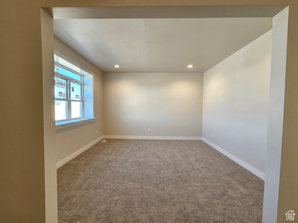 Carpeted spare room featuring a textured ceiling