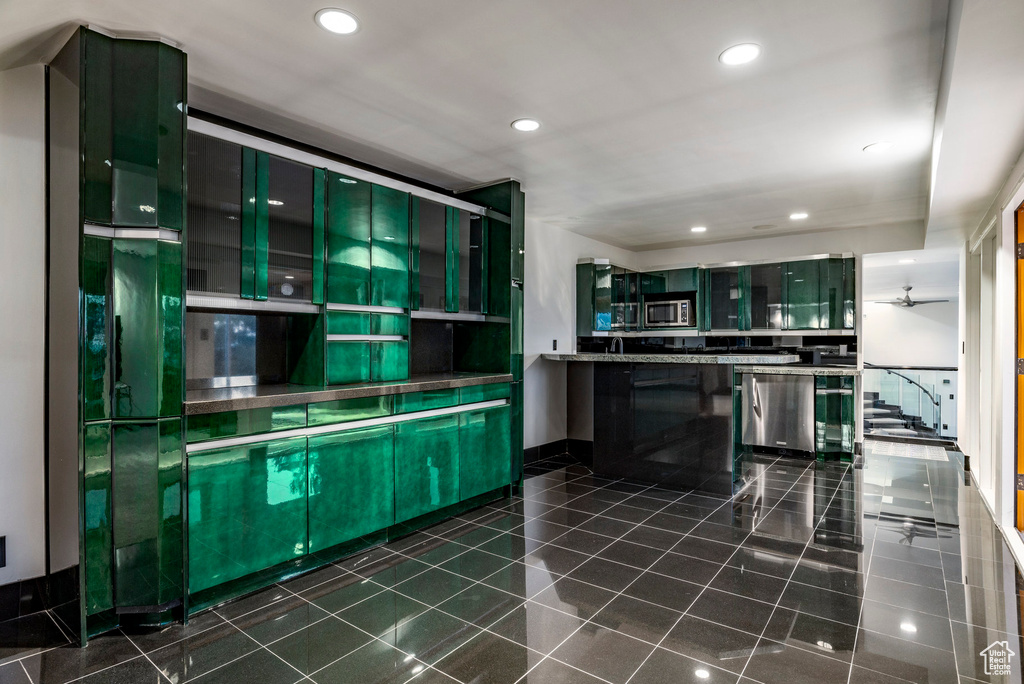 Kitchen with stainless steel appliances, recessed lighting, glass insert cabinets, and dark tile patterned flooring