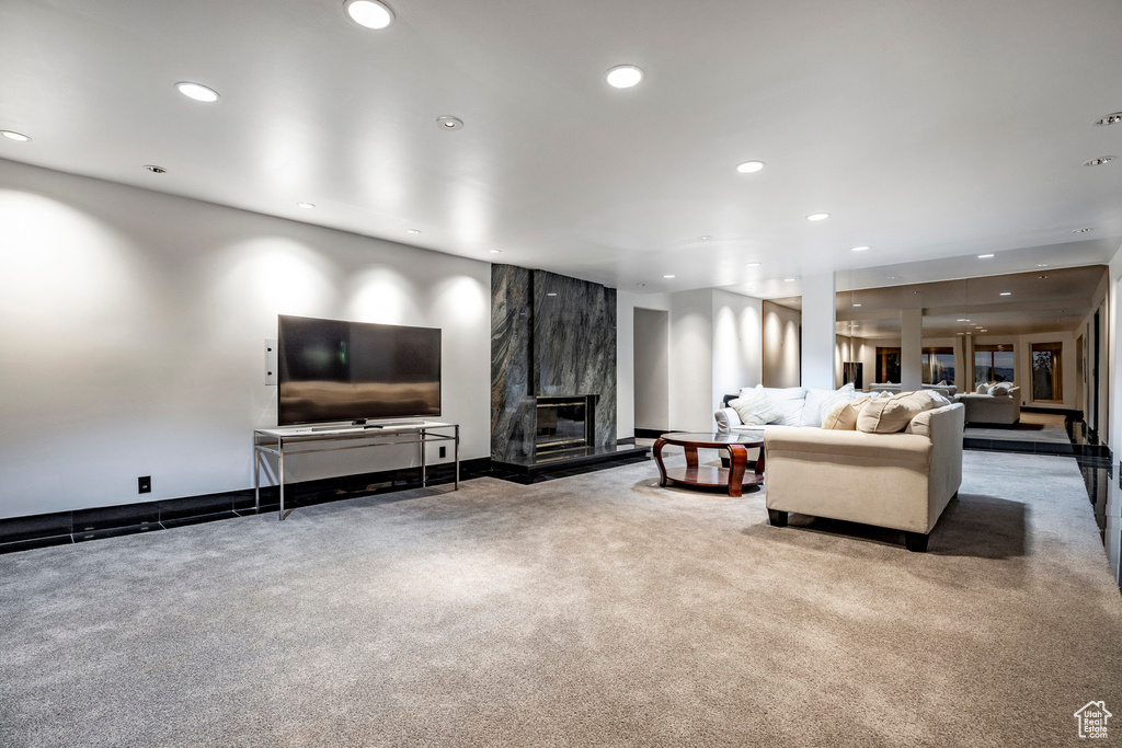Living room featuring recessed lighting, carpet flooring, and a fireplace