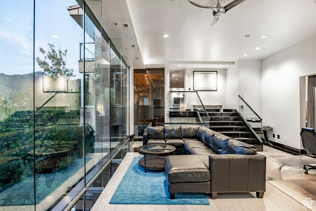 Living area with a ceiling fan, stairway, and recessed lighting