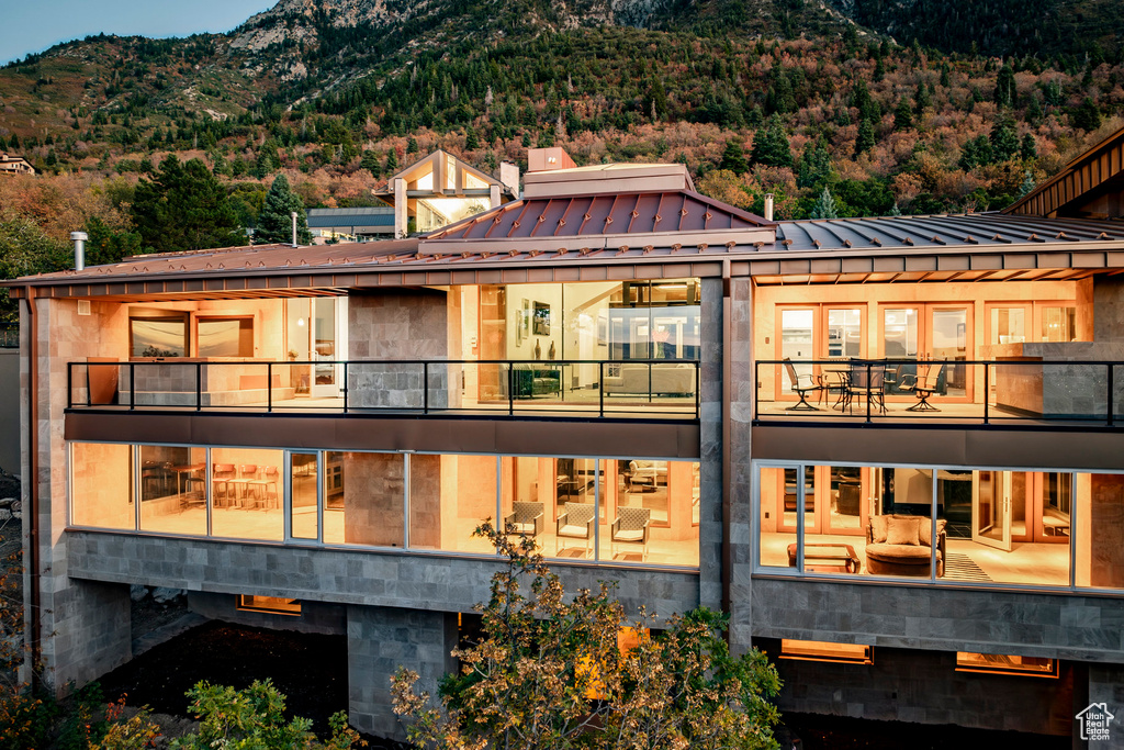 Back of property featuring a mountain view, a balcony, and metal roof
