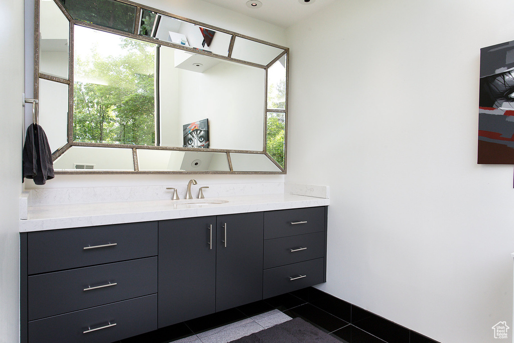 Bathroom featuring vanity, tile patterned floors, and healthy amount of natural light