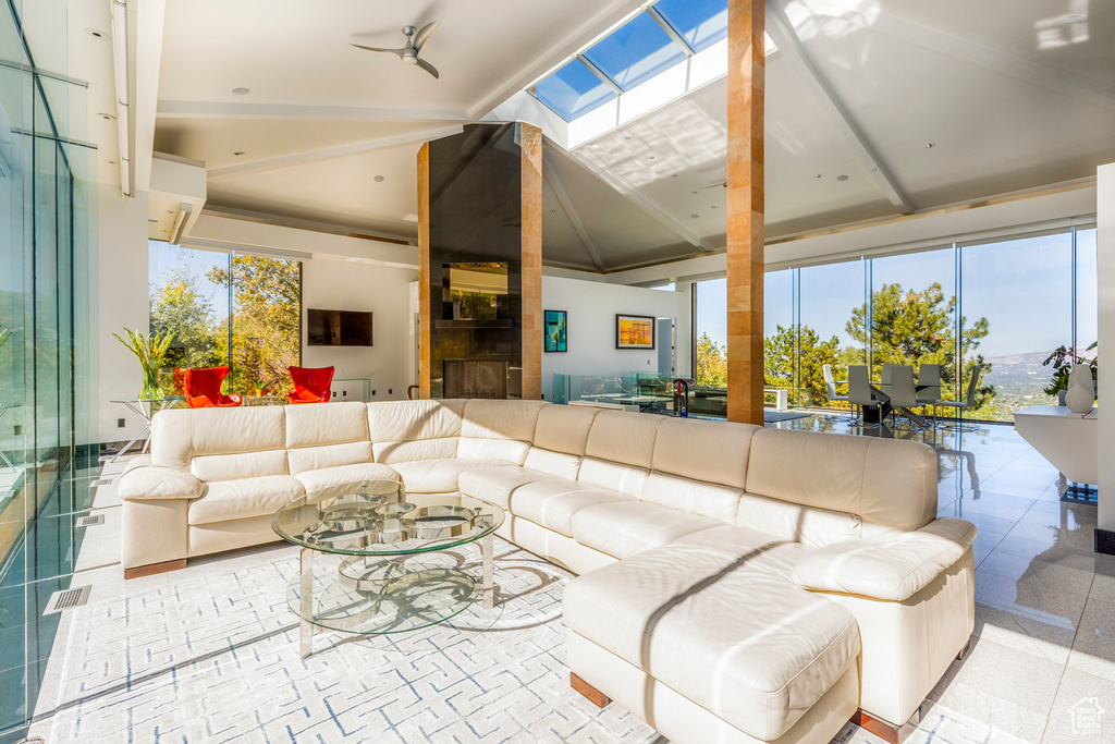 Living room with ceiling fan and lofted ceiling with skylight