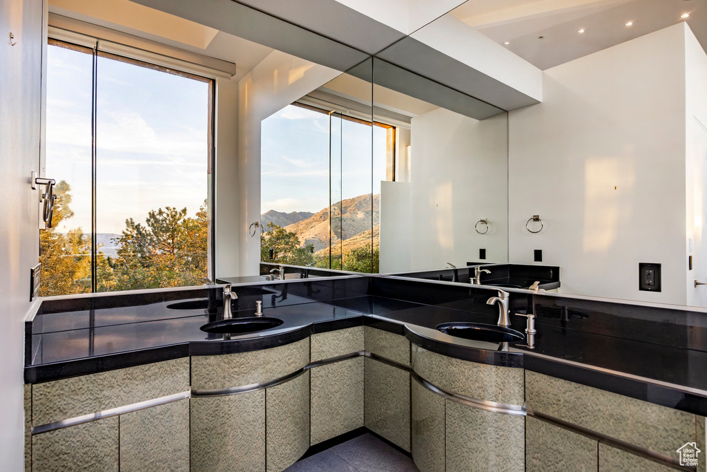 Bathroom with double vanity, a mountain view, and recessed lighting