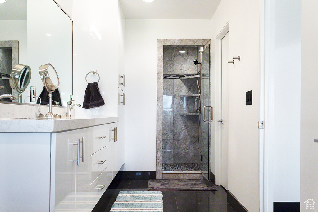 Bathroom with tile patterned floors, vanity, and a shower with shower door